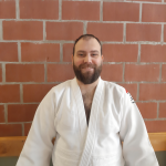 Een foto van Pieter Severijns met judo outfit tegen een stenen muur.