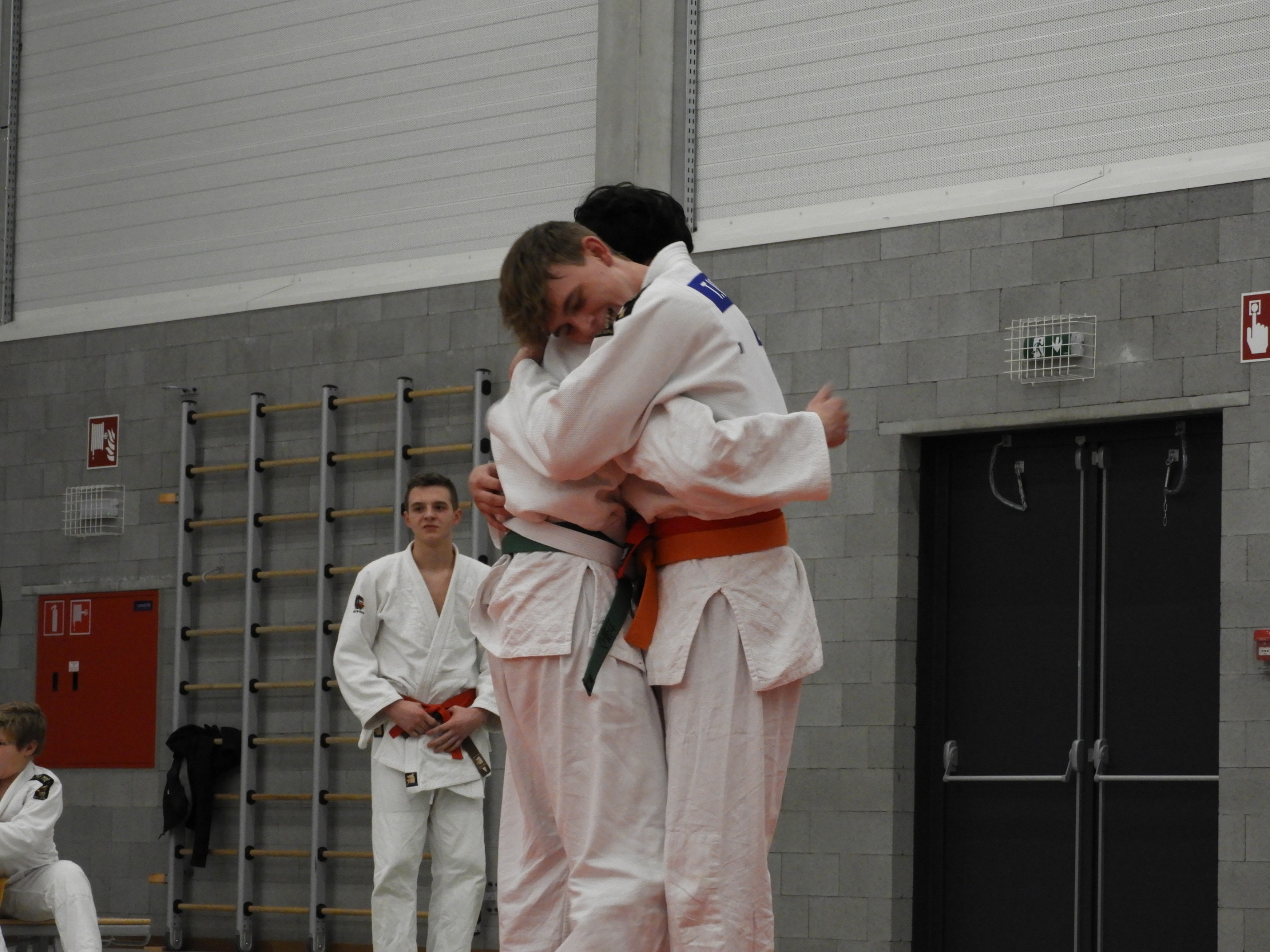 Twee judo tegenstander die elkaar een knuffel geven.
